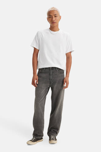 Jean droit en denim gris foncé de Levi's, porté avec un T-shirt blanc et des chaussures noires.