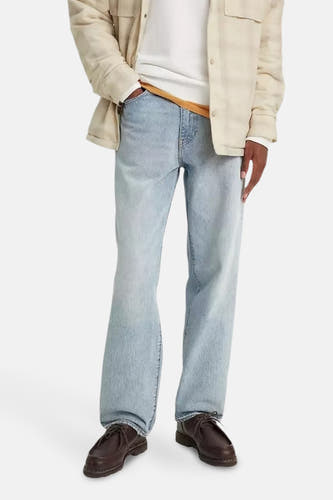 Jean droit bleu clair de Levi's, avec une tenue décontractée et des chaussures marrons.
