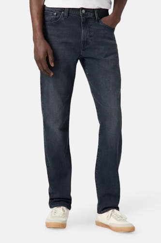 Jean tapered en denim gris foncé de Levi's, porté avec un t-shirt blanc et des chaussures blanches.