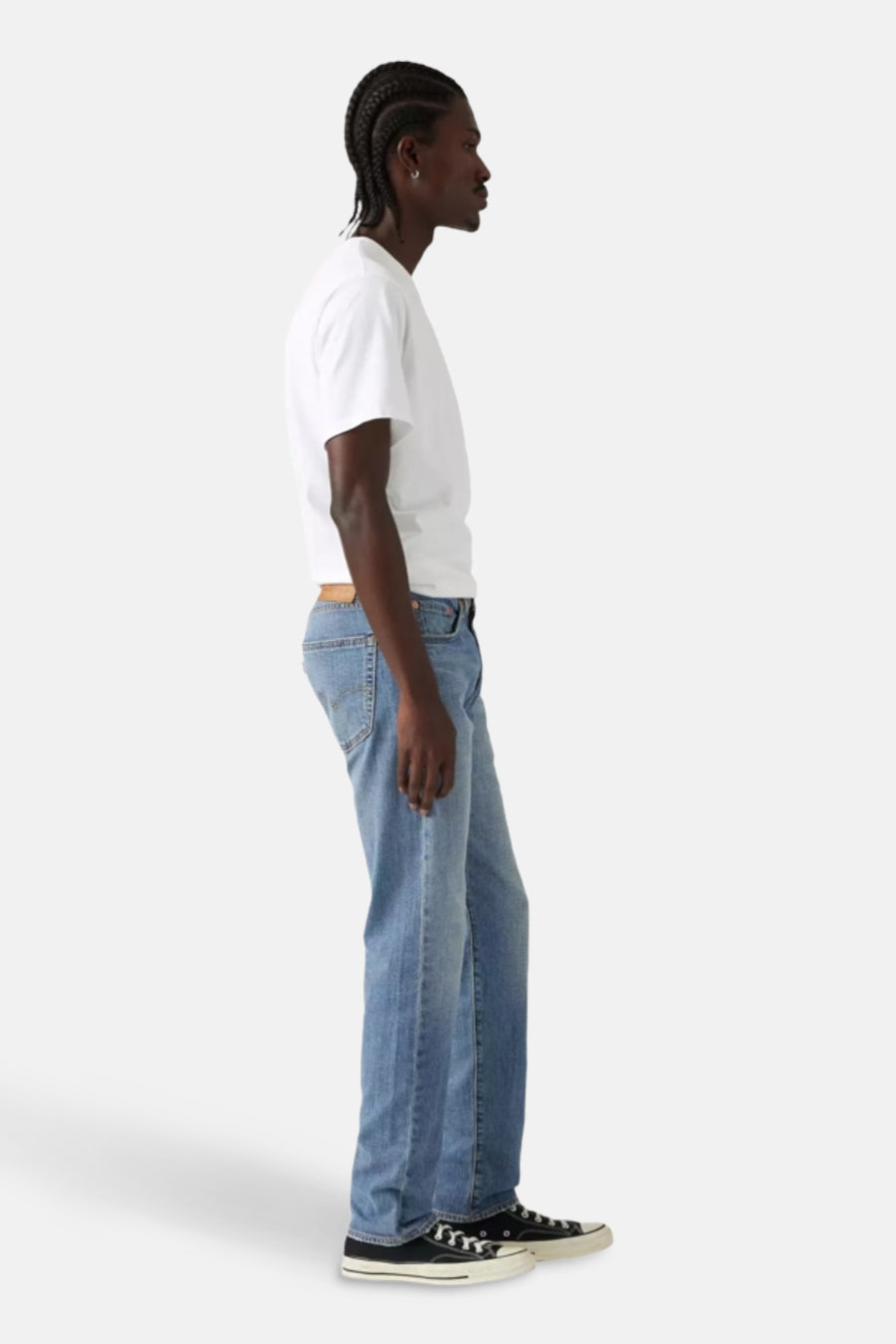 Lichtblauwe tapered jeans van Levi's®, met een bruine riem en zwarte sneakers.