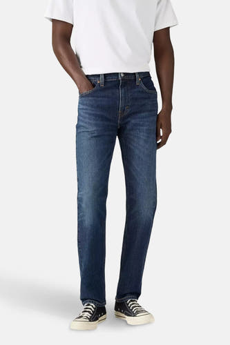 Jean tapered en denim bleu marine de Levi's, porté avec un T-shirt blanc et des baskets noires.