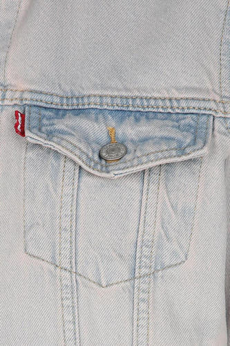 Veste en jean bleu clair de Levi's, avec poche poitrine à bouton et étiquette rouge de la marque sur le côté.