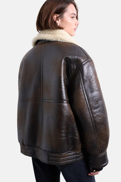 Bruine korte jas van TOPSHOP, met een crèmekleurige kraag van imitatiebont, gezien van achteren.
