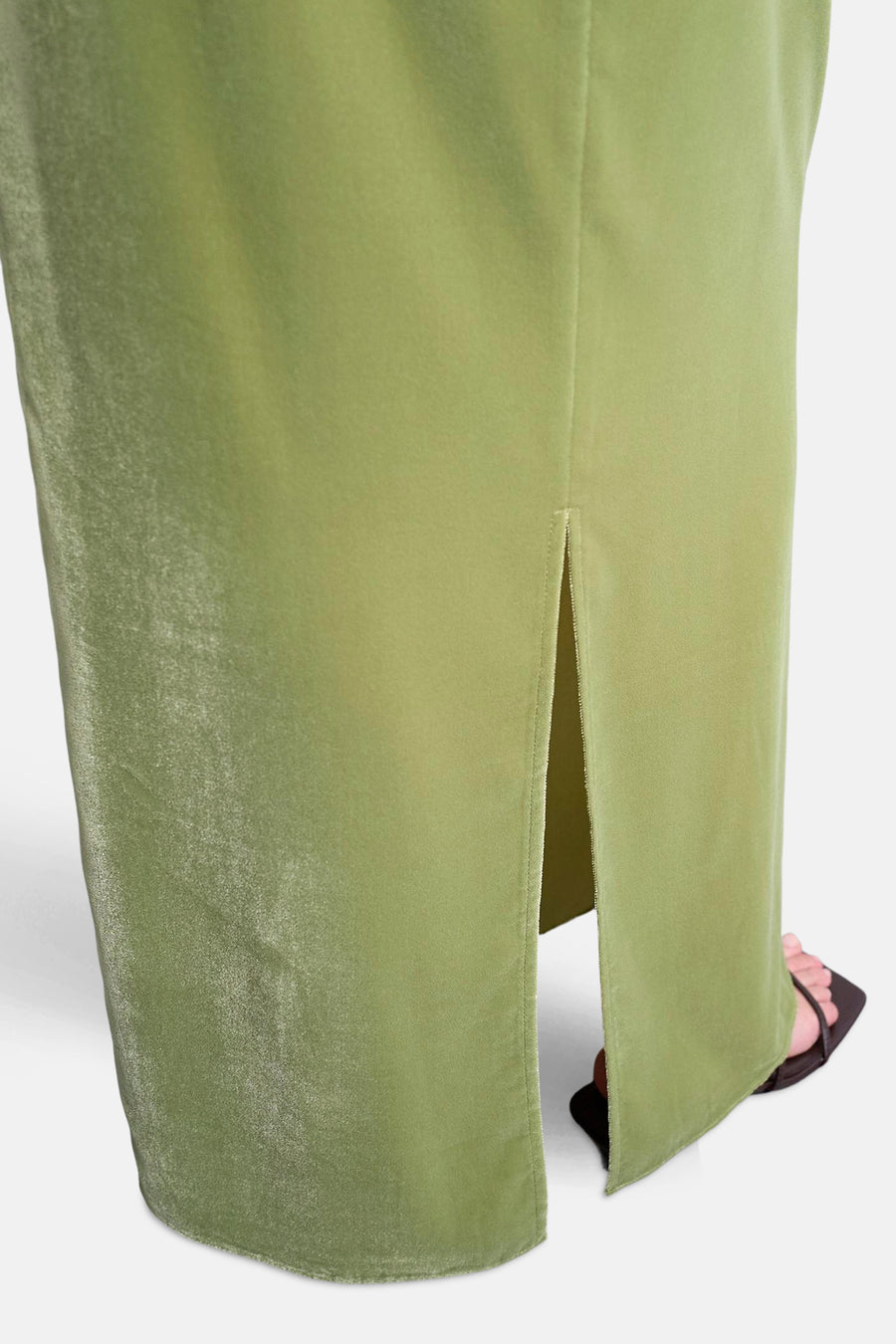 Olijfgroene fluwelen jurk met split en zwarte sandaal.
