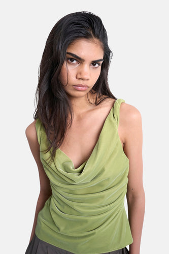 Vrouw in groene, geplooide fluwelen top.