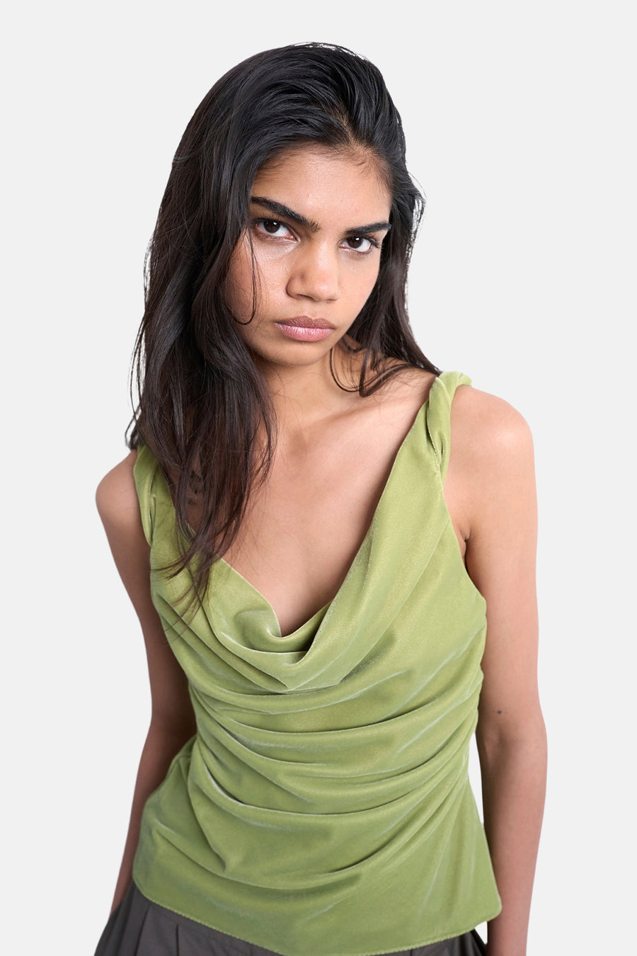 Vrouw in groene, geplooide fluwelen top.