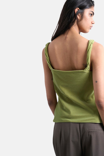 Olijfgroene top met gedraaide bandjes, draagster van achteren gezien, bijpassende broek.