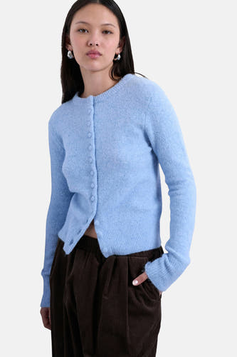 Veste bleue de TOPSHOP, avec fermeture à boutons et portée avec un pantalon corduroy marron.