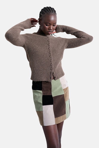 Veste brune de TOPSHOP, à fermeture à boutons, portée avec une jupe patchwork.