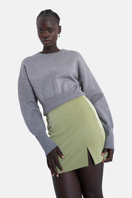 Robe courte verte de TOPSHOP, avec une fente sur le côté et un pull gris.