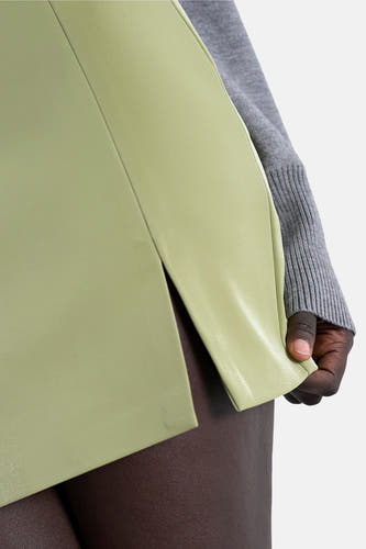 Groene korte rok van TOPSHOP, met een split aan de zijkant en een grijze trui.