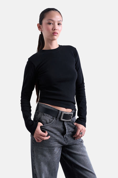 T-shirt noir à manches longues de TOPSHOP, porté avec un jean gris et une ceinture.