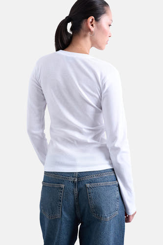 T-shirt blanc à manches longues de TOPSHOP, vu de derrière, associé à un jean bleu.