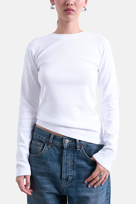 T-shirt blanc à manches longues de TOPSHOP, porté avec un jean bleu et des boucles d'oreilles argentées.