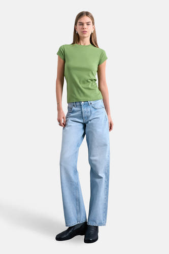 T-shirt vert à manches courtes TOPSHOP, porté avec un jean ample et des chaussures noires.