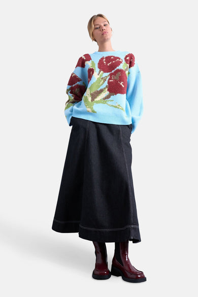 T-shirt bleu avec col rond de TOPSHOP, imprimé de fleurs et associé à une longue jupe sombre et des bottes brunes.