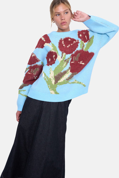 T-shirt bleu marine à col rond de TOPSHOP, associé à des motifs floraux rouges et une jupe en denim noir.