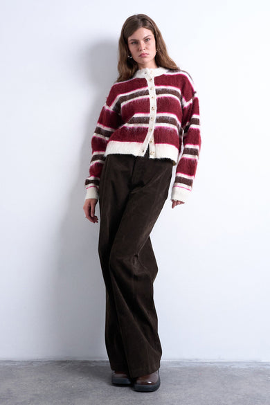 Veste multicolore de TOPSHOP avec des rayures horizontales en rouge, marron et blanc, portée avec un pantalon marron.