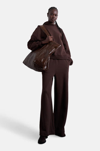 Pull-over marron avec capuche de TOPSHOP, porté avec un sac marron et un pantalon large.