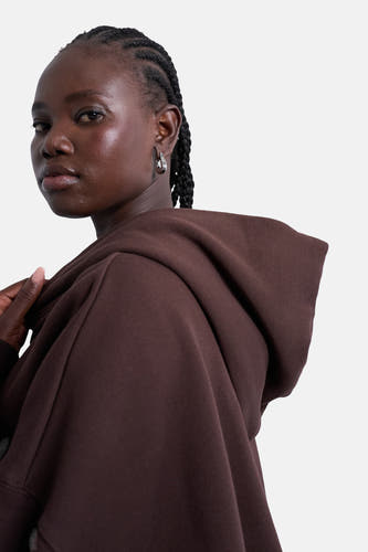 Pull-over marron avec capuche de TOPSHOP, avec des boucles d'oreilles argentées et cheveux tressés.