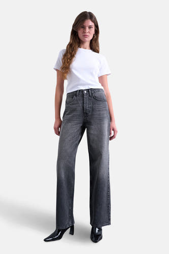 Jean droit noir de TOPSHOP, associé à un T-shirt blanc et des bottes noires.