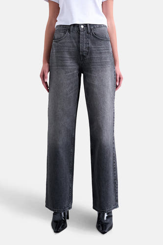 Jean droit noir de TOPSHOP, avec une texture stonewash et porté avec des bottines en cuir noires.