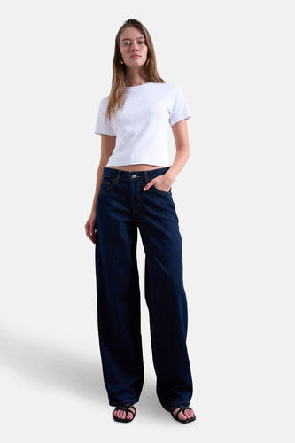 Jean droite bleu foncé de TOPSHOP, combiné avec un t-shirt blanc et des escarpins noirs.