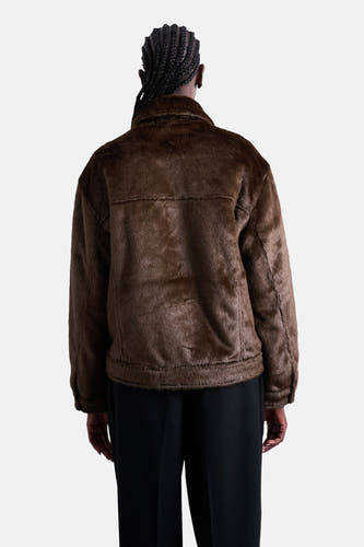 Manteau court brun de TOPSHOP, vu de de derrière, avec une texture fourrée et un pantalon noir.