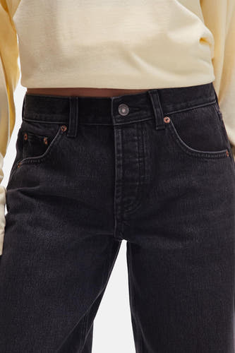Zwarte wijde jeans van TOPSHOP, met stonewash effect en koperkleurige details op de zakken.
