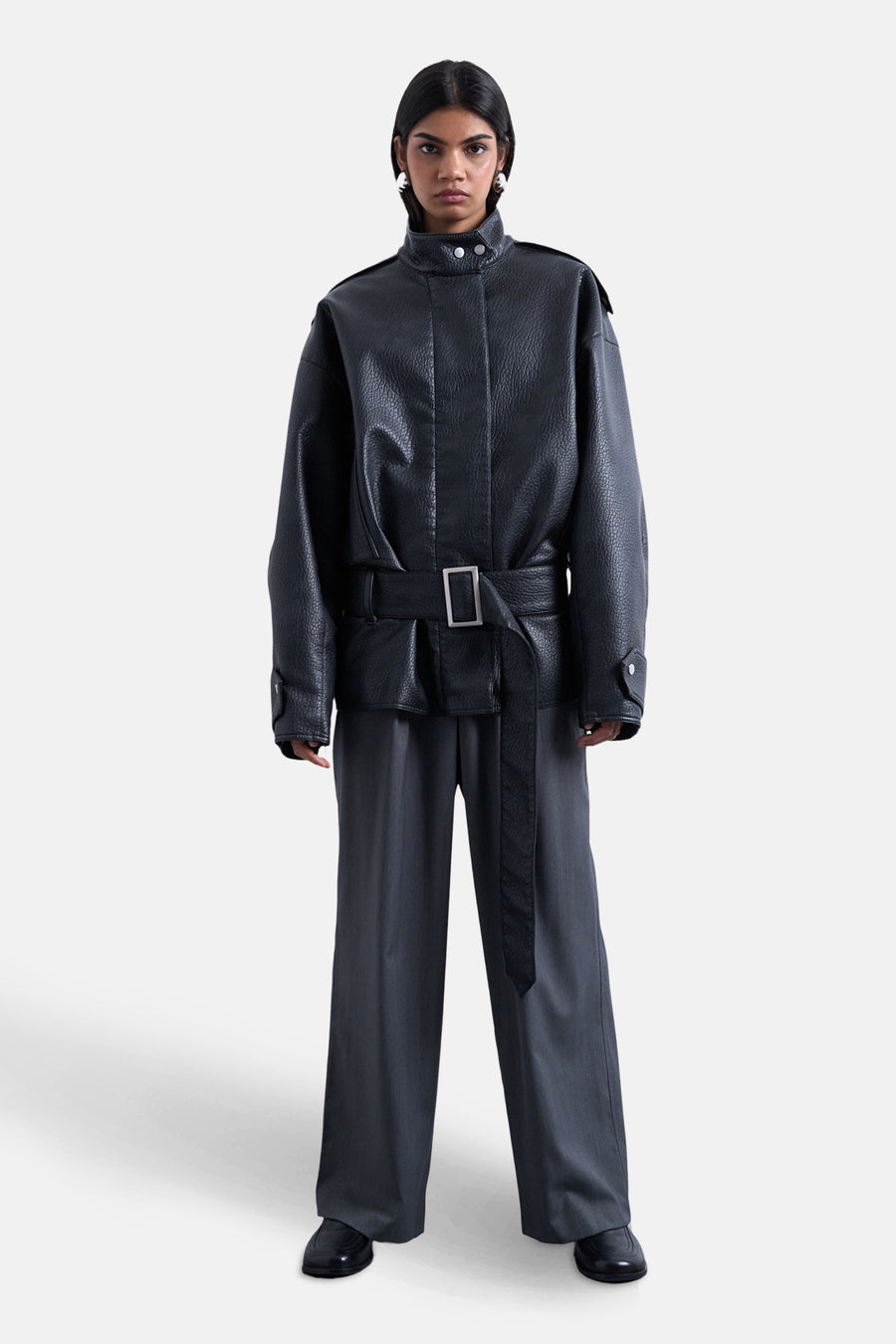 Jean gris de TOPSHOP, associé à une veste en cuir noire avec ceinture et des chaussures noires.