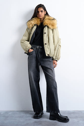 Manteau court vert de TOPSHOP, avec un col en fourrure imitée et porté avec des jeans noirs et des chaussures noires.