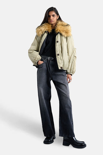 Groene jas van TOPSHOP, met een bontkraag, gecombineerd met donkere jeans en zwarte schoenen.
