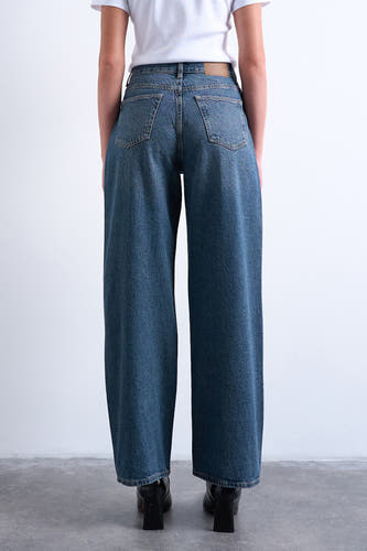 Jean droit bleu denim de TOPSHOP, vu de derrière avec des jambes droites et des chaussures à semelles noires.