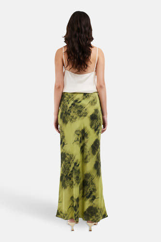Longue robe verte de TOPSHOP, avec un motif floral noir, associée à une chemise blanche.