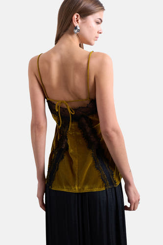 Groene mouwloze blouse van TOPSHOP, met zwart kant, spaghettibandjes en strikdetail op de rug, gedragen met een zwarte rok.
