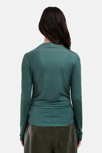 Groen T-shirt met lange mouwen van TOPSHOP, gezien van de achterkant, met een groene leren broek.
