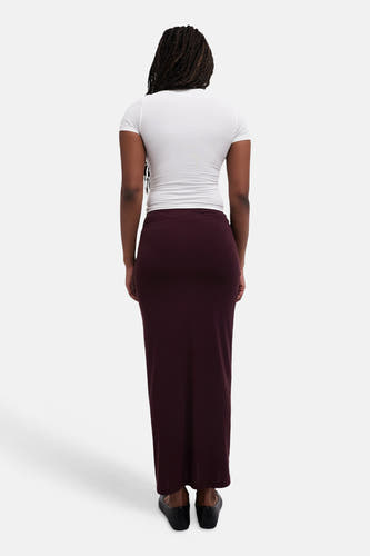 Long manteau rouge de TOPSHOP, vu de derrière, associé à un t-shirt blanc et des chaussures noires.