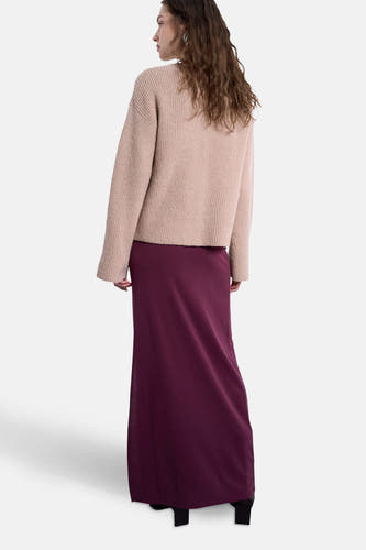 Longue jupe rouge de TOPSHOP, associée à un pull tricoté dans une couleur neutre, vue de dos.