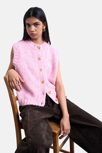 T-shirt rose de TOPSHOP, avec une texture côtelée, porté avec un pantalon marron et des boucles d'oreilles triangulaires.