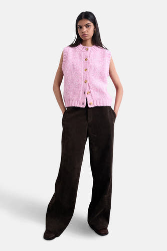 T-shirt rose de TOPSHOP, avec col en boutons et coupe sans manches, associé à une pantalon marron.