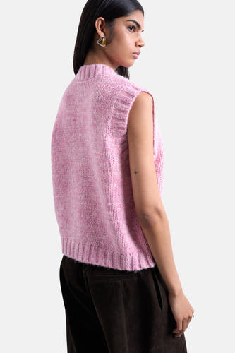 Roze debardeur van TOPSHOP, met een gebreide textuur, gedragen met een bruine broek en driehoekige oorbellen.

