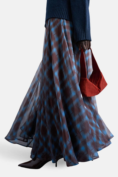 Long jupe multicolore de TOPSHOP, avec un motif à carreaux et associée à une chemise bleue.