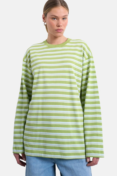 T-shirt à manches longues vert TOPSHOP, avec rayures horizontales blanches et bleues, avec bras croisés.