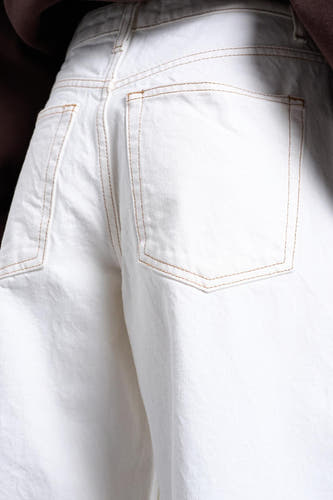 Jeans en denim blancs coupe spéciale de TOPSHOP, avec surpiqûres dorées sur les poches arrière.