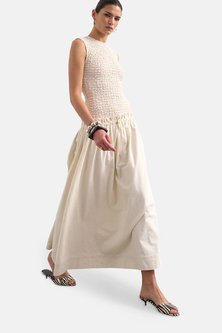 Robe écru à manches courtes de TOPSHOP, avec un haut ajusté et une longue jupe, porté avec des mules à imprimé zèbre.