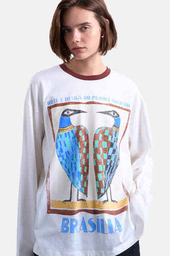 T-shirt blanc à manches longues de TOPSHOP, avec encolure ronde et porté avec un jean foncé.