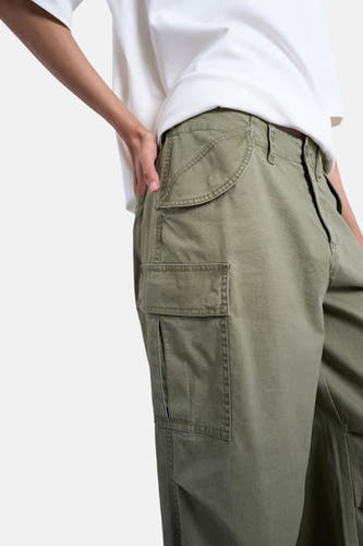 Pantalon cargo vert TOPSHOP, avec poches plaquées et coupe décontractée, porté avec un t-shirt blanc.