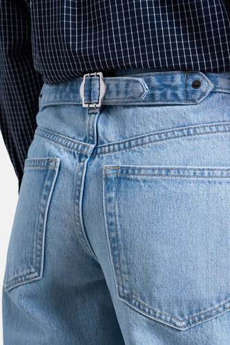 Jeans en denim bleu clair large de TOPSHOP, avec ceinture et boucle argentée, vue arrière.