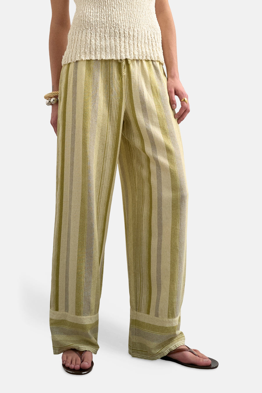 Pantalon vert à rayures verticales TOPSHOP, associé à un haut en maille sans manches et des sandales.