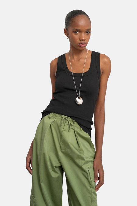 Débardeur noir de TOPSHOP, avec une texture côtelée, porté avec un pantalon cargo vert et une chaîne argentée.